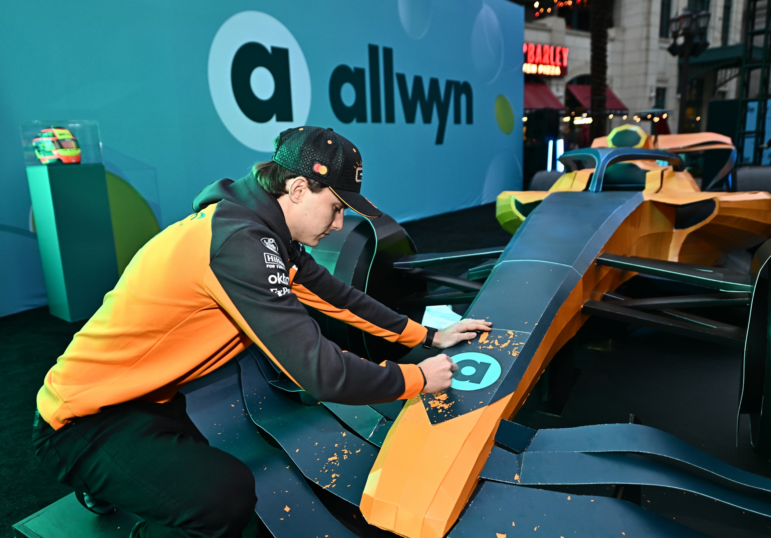 Oscar Piastri scratches the first panel on the Scratch Car launched by Allwyn and the McLaren F1 Team