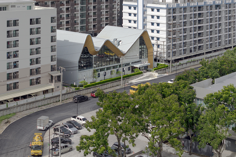 three asymmetrical curved gable roofs top ASWA’s community hub in thailand