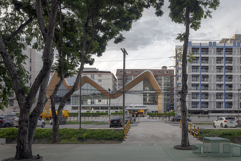 three asymmetrical curved gable roofs top ASWA’s community hub in thailand