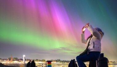 Image of someone taking a photo of the northern lights