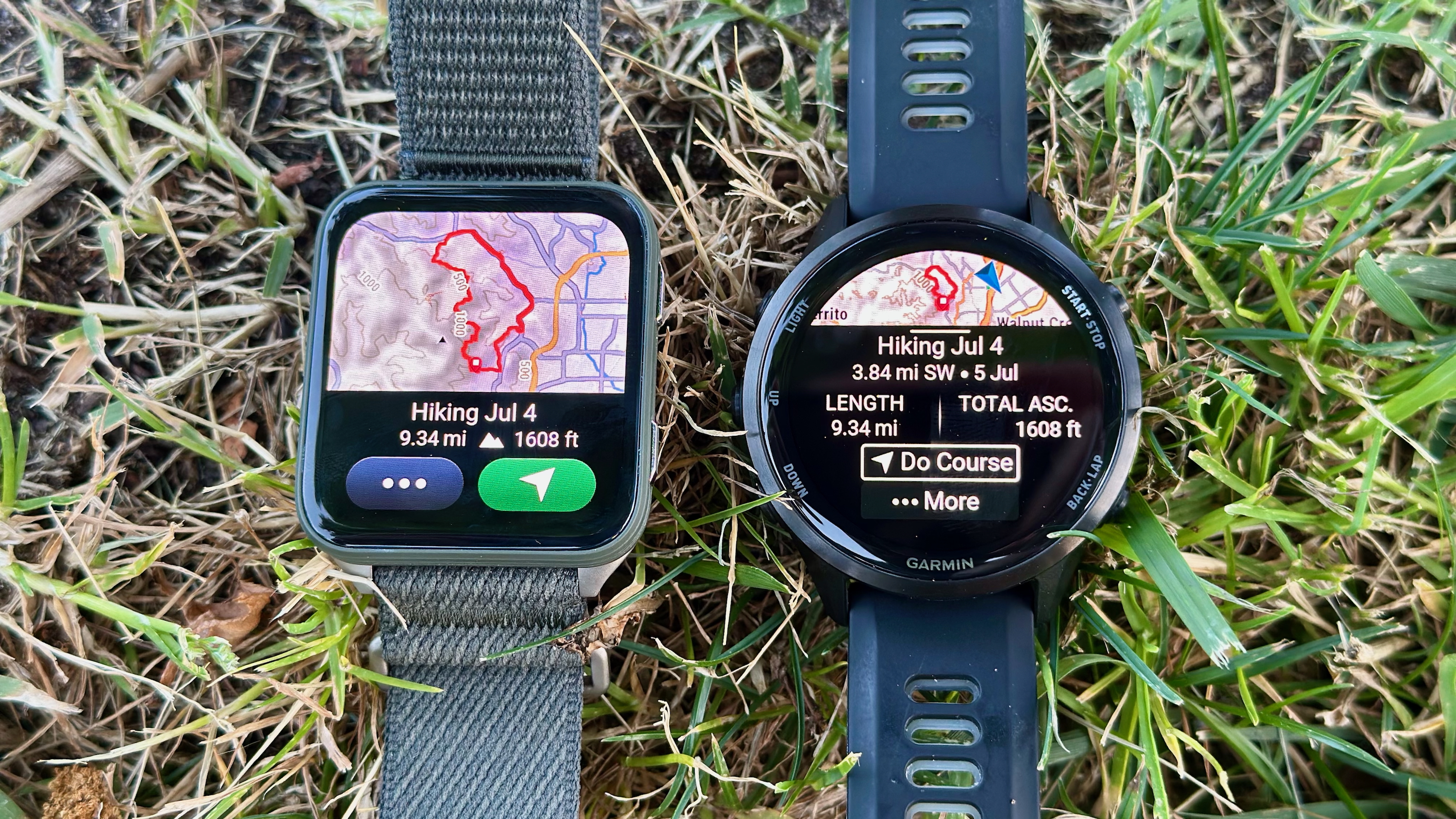 The Garmin Venu X1 (left) and Garmin Forerunner 970 (right) sitting aside each other on a lawn, both showing the same 9-mile hiking course, but the larger, square-shaped X1 display shows much more map info.