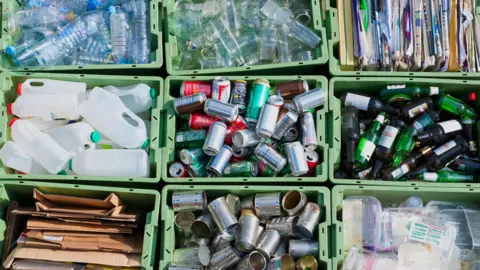 Getty Images A selection of waste in different boxes divided up into plastic bottles, milk bottles, cans, glass bottles, cardboard and paper