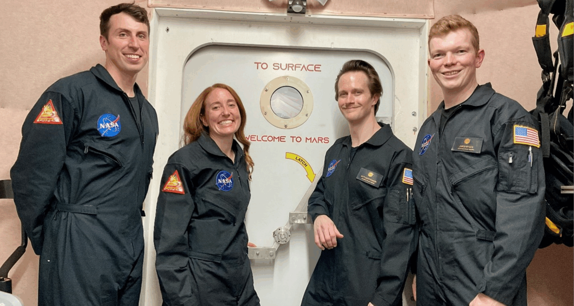 CHAPEA mission 2 crew members (from left) Ross Elder, Ellen Ellis, Matthew Montgomery, and James Spicer, pose in front of the door to the simulated Martian landscape for their first photo inside the CHAPEA habitat after their mission began in October 2025