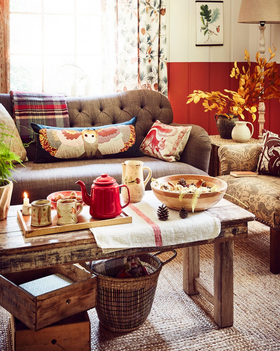autumnal interior. rich, earthy tones of red, amber and burnt orangea russet wall colour used to dado height, with a pale neutral above. paired with comforting tones of brown and red and a mix of textures, from a jute rug and weathered wood table to appliquÃ©d cushions, which reflect materials or patterns from the natural world. animal print cushions,sofa,coffee table with red enamel teapot and mugs.walls painted in tuscan red intelligent eggshell, Â£62/2.5l, little greene, and slate ii architectsâ€™ eggshell, Â£66.50/2.5l, paint paper library. curtain in owlswick teal cotton linen mix, Â£59/m, sanderson at style library. burford medium sofa in chocolate, Â£1,279, country living collection exclusively available at dfs. red squirrel cushion, Â£70, peaceable kingdom cushions. flying owl appliquÃ© cushion, Â£144, carola van dyke. recycled wool throw, Â£18; merino cushion in sa ron (just seen), Â£79: both the future kept. oak leaves and acorn a3 canvas, Â£19.99, bygone press available from etsy. wooden floor lamp, Â£175, cox cox. lampshade, similar, nkuku. twig stool, from Â£875, pinch. ceramic jugs, flea market finds. one o upholstered armchair in battle great wood wool, from Â£1,000, lindsay alker. varx block printed cushion, Â£75, bonfield block printers. book, from a selection, the old haberdashery. one o rustic co ee table, Â£325, home barn. wooden bowl and ceramic jug: both flea market finds. red stripe linen, similar, beyond france. wooden plant pot and plant, from a selection, the conran shop. wooden tray, similar, muji. slip decorated earthenware mugs, Â£20 each, josie walter. enamel teapot (part of set with mugs, not shown), Â£24, fforest. soup bowl by wonki ware, Â£22; jute rug, from Â£275: both the conran shop. wooden boxes, similar, home barn. basket, similar, habitat