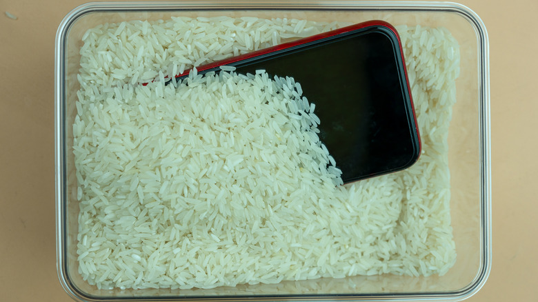 An illustration showing a phone placed in a rice bowl to fix water damage