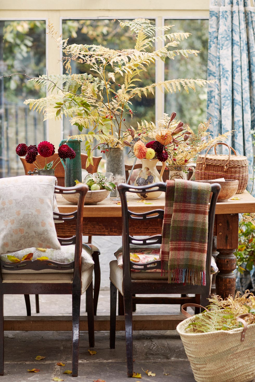 dinning room table and two dining room chairs with foilage and flowers as a centre piece on the table. window behind thhe table looking out to the garden.use jugs of flowers and foliage to create a simple centrepiece for your table.autumn tableantique mahogany chairs,from Â£35 each; old pine table,from Â£60; vintage ceramic jugsand bowls, from a selection: alltrecastle antiques. galvanizedmetal jug, from Â£12, norpar.lidded basket, from aselection, ebay. curtains incotton toile de jouy, froma selection; cushions in fabrics,from Â£24/m: all sanderson.plaid wool scarf, Â£21,scotland shop. woven marketbasket with leather handles,Â£22, labour and wait