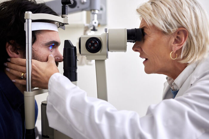 Ophthalmologist examining patient's eye using slit lamp in a clinical setting, highlighting doctor versus Dr. Google concept.