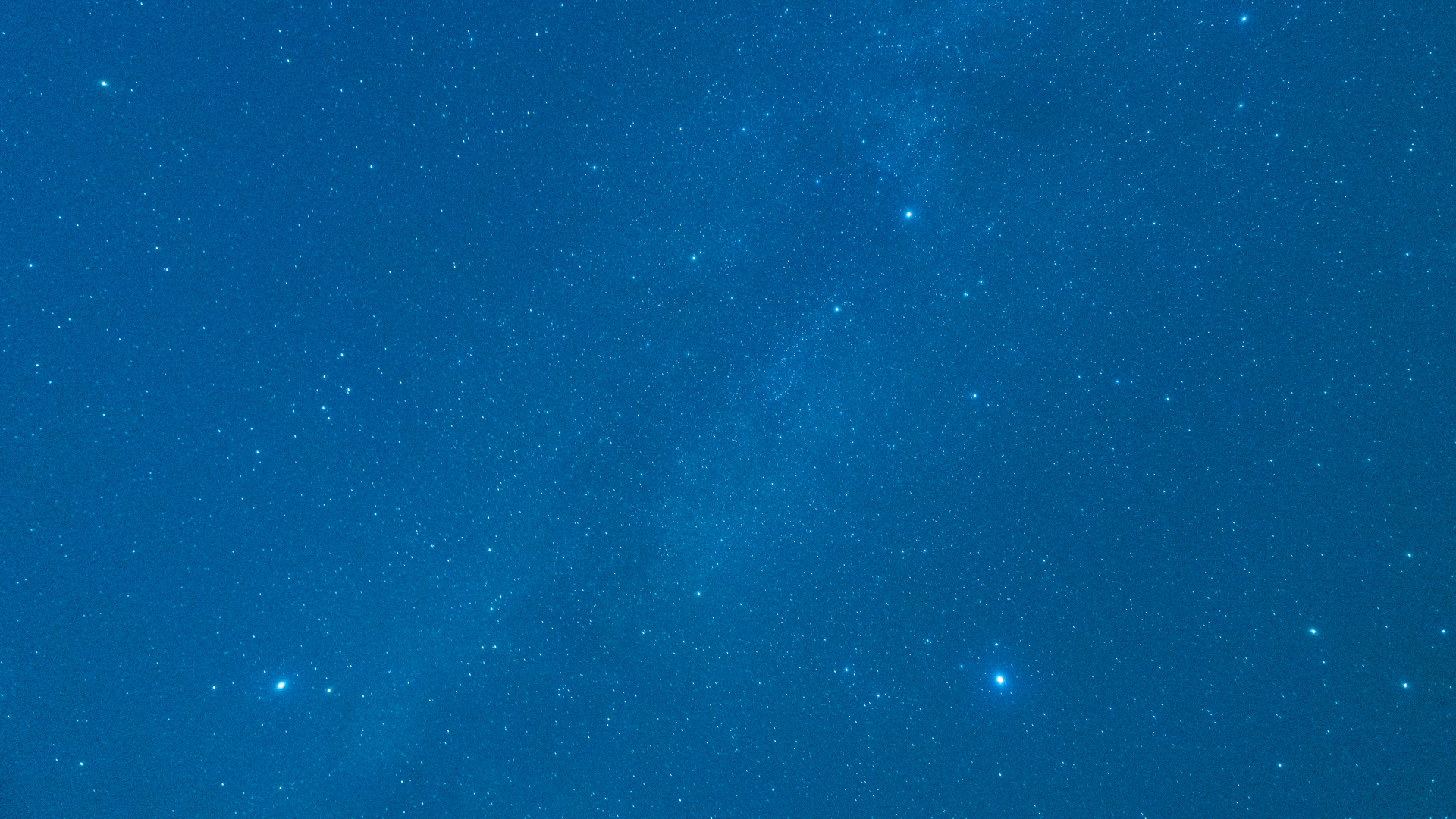 Three bright stars make a triangle shape in a royal blue night sky