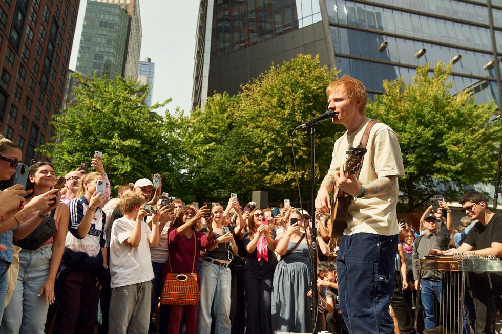 one shot with ed sheeran. ed sheeran singing to a crowd in the streets.