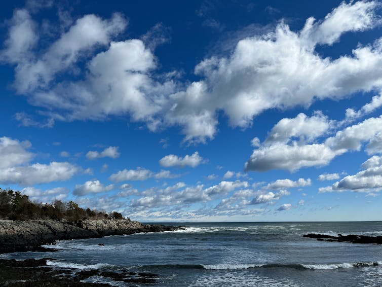 a cloudy sky above a rocky shoreline