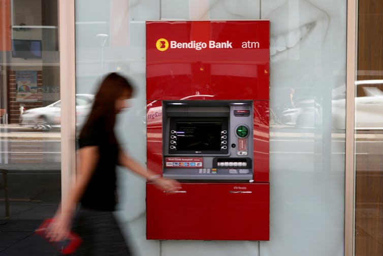 A person seen walking past a Bendigo Bank ATM