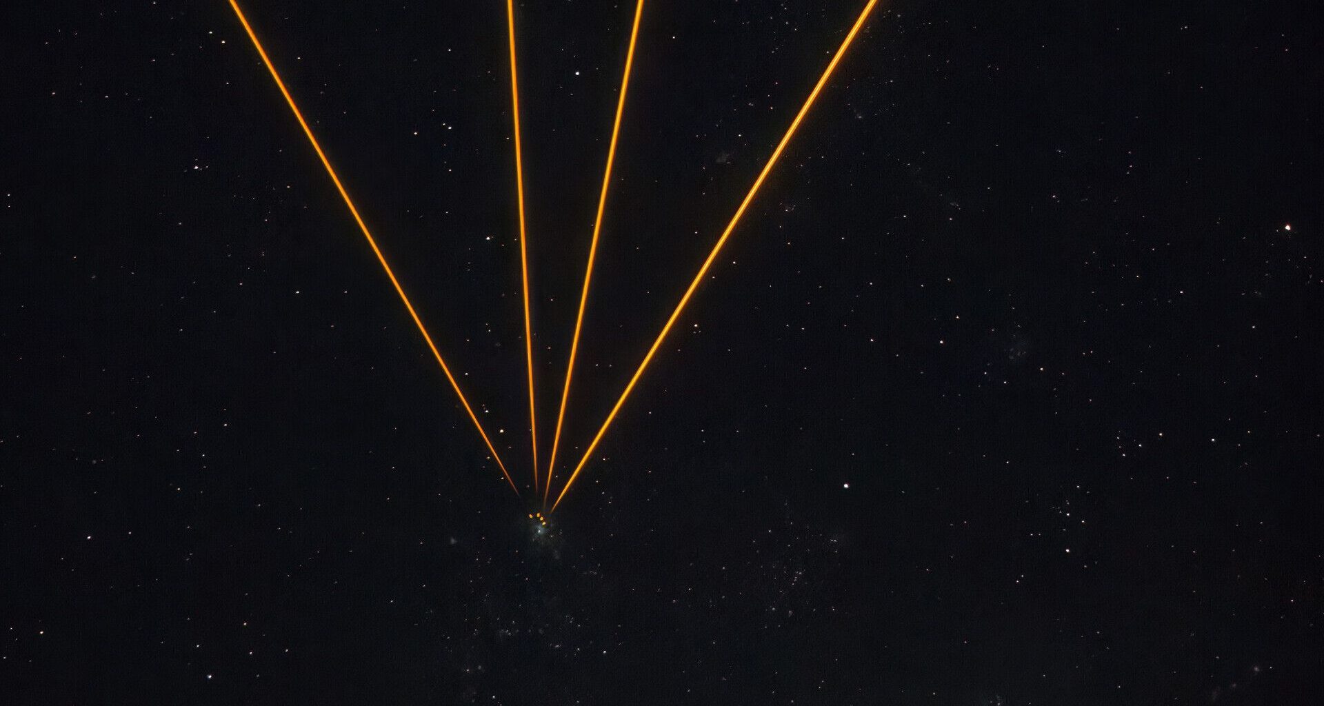 A series of golden lines converging to one point in a starry night in the center of the image