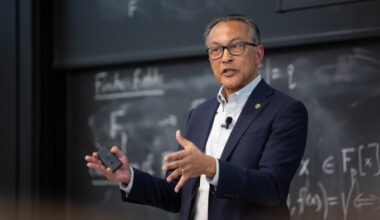 Ani Dasgupta speaks while gesturing during the 2024 Earth Day Colloquium, standing in front of a chalkboard.