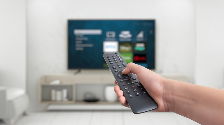 Google TV interface with a man holding remote