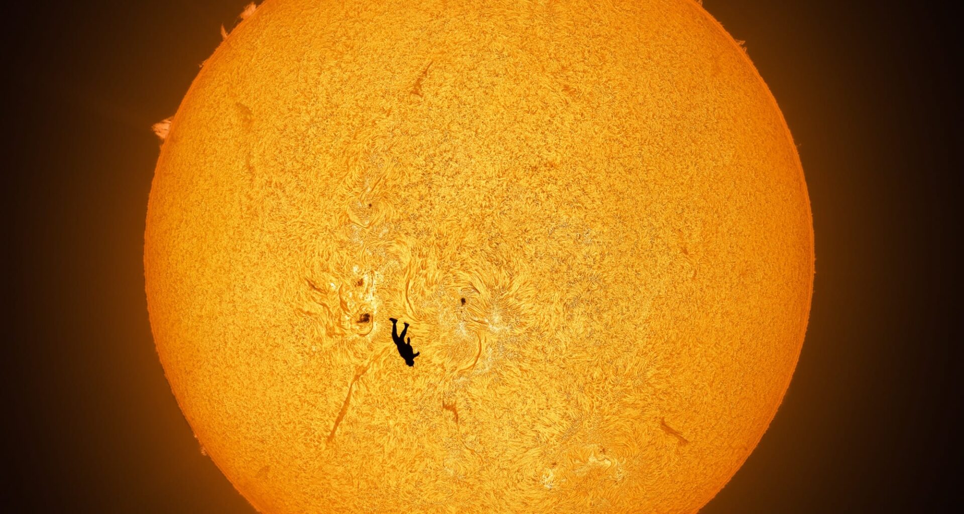 an image by Andrew McCarthy of a skydiver falling in front of the sun