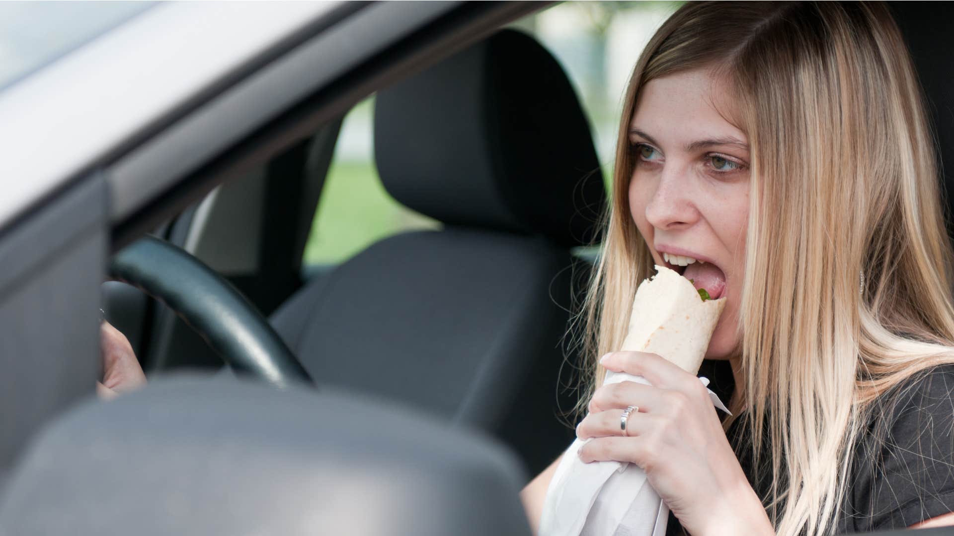 woman eating takeout in her car