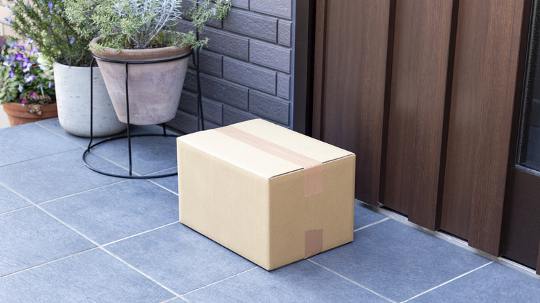 A cardboard box package sitting on a doorstep