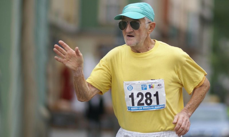 older man running marathon outside