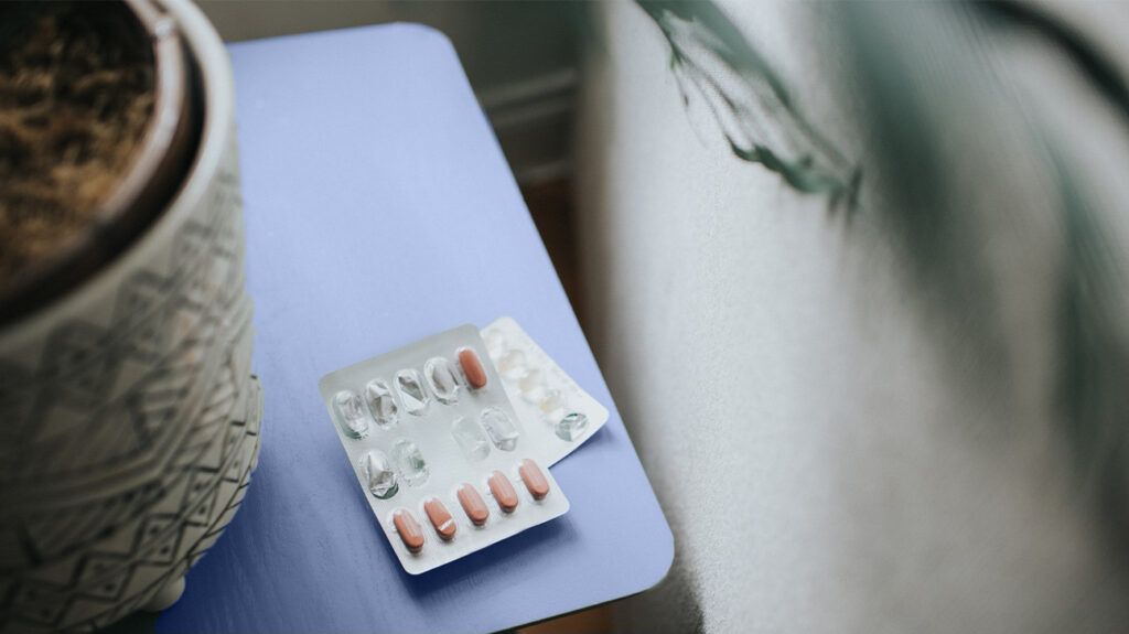 blister pack of vitamin D supplements on blue table