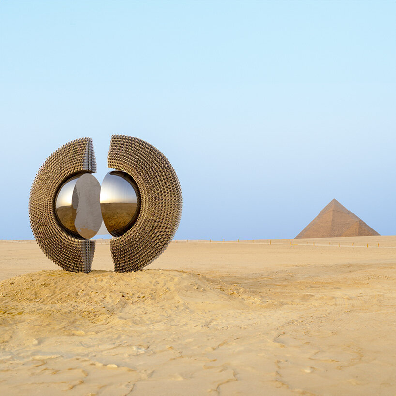 reflective aluminum sculpture by mert ege köse splits apart to frame the giza pyramids