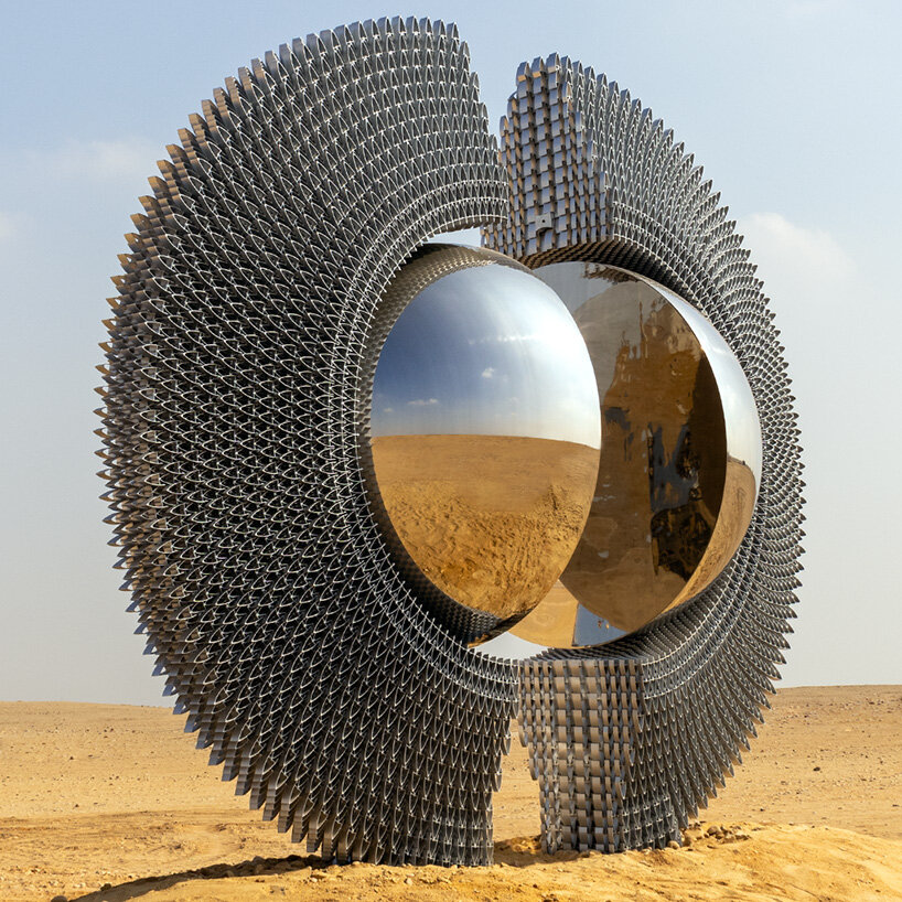 reflective aluminum sculpture by mert ege köse splits apart to frame the giza pyramids
