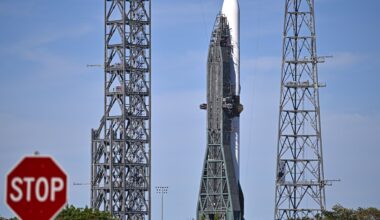 a photo of Blue Origin's New Glenn rocket with a "stop" sign visible in the foreground