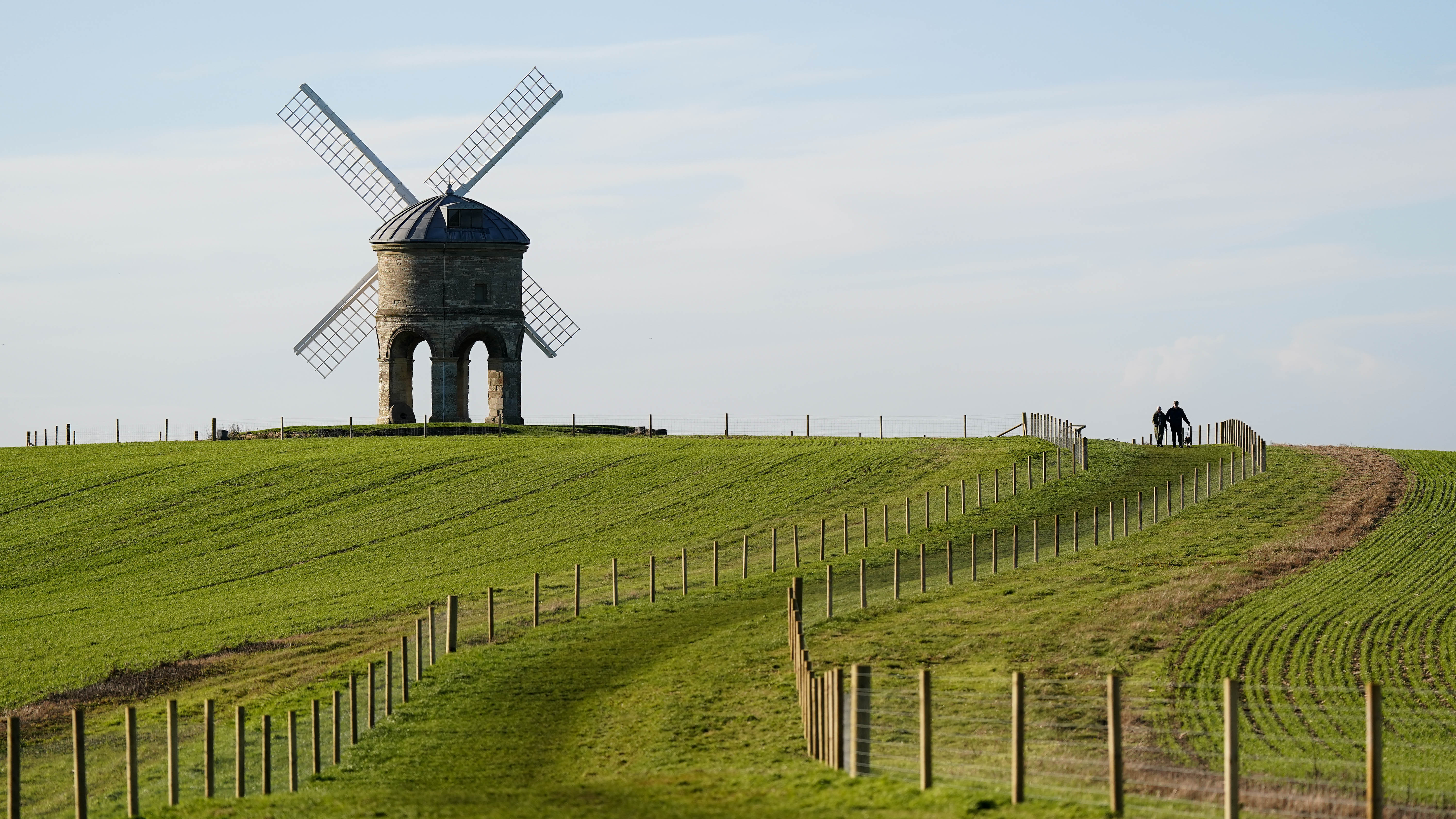 People walking their dog by Chesterton Windmill in Warwickshire.