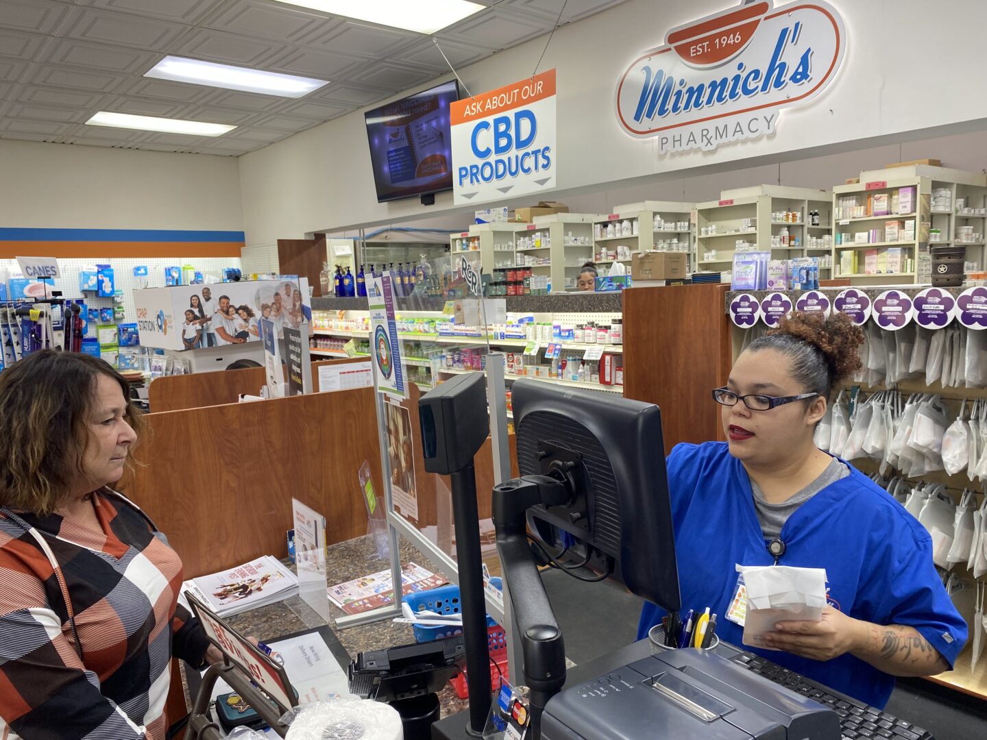 Customer Lisa Durs is helped by pharmacy clerk Kira Tomoney at Minnich's Pharmacy in York County.