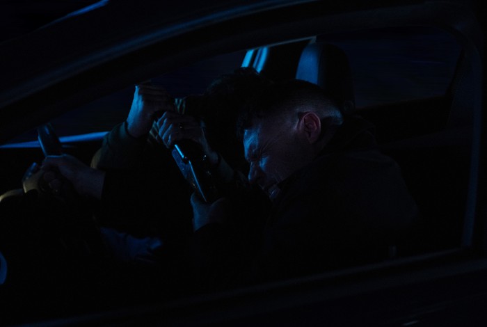 Aaron tries to wrestle the gun off John in a darkened car in a scene from Emmerdale