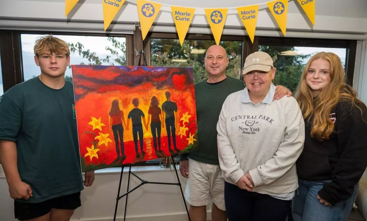 A family standing next to a colourful easel 