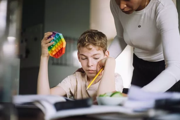 Woman helping a boy with his homework, school, class work