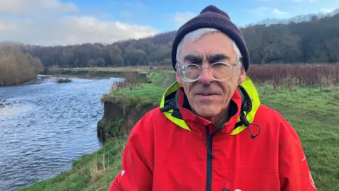 Chris Malkin pictured with the River Irwell behind him.