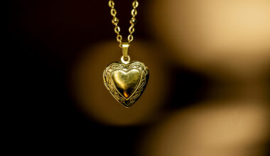 A gold-tone heart-shaped locket hangs on a gold-tone chain.