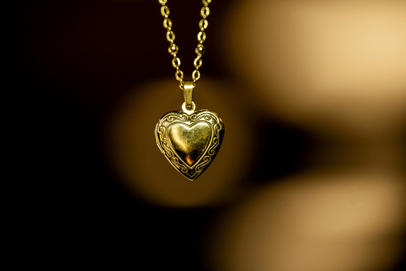 A gold-tone heart-shaped locket hangs on a gold-tone chain.