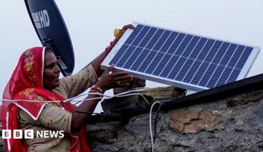 An Indian worker sprays water onto panels of India's first 1MW canal-top solar power plant at Chandrasan village of Mehsana district, some 45 kms from Ahmedabad on World Earth Day, April 22, 2012.
