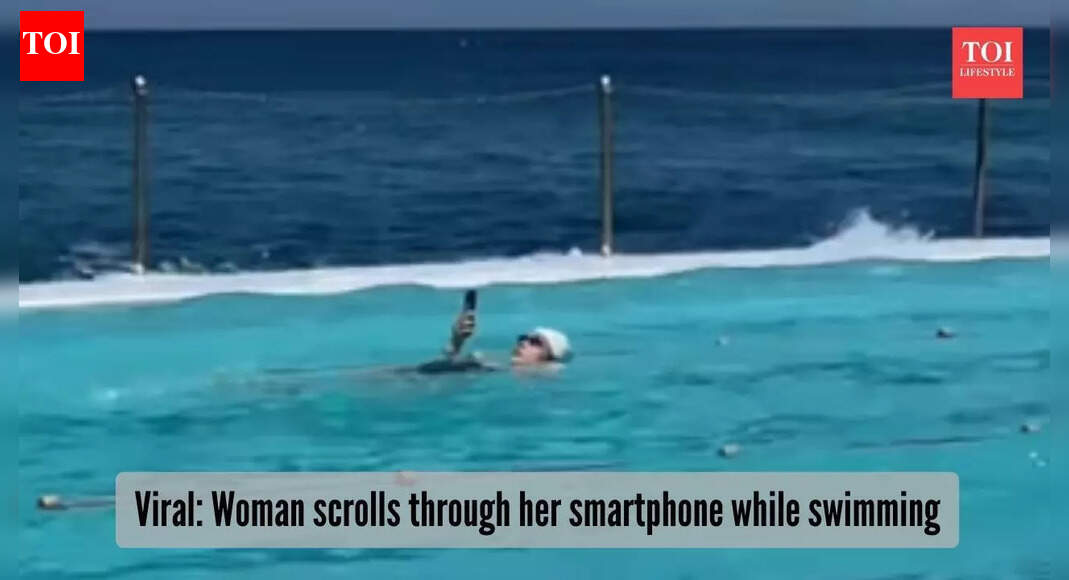Peak addiction or beach boss move? Woman scrolls through phone while swimming, video goes viral |