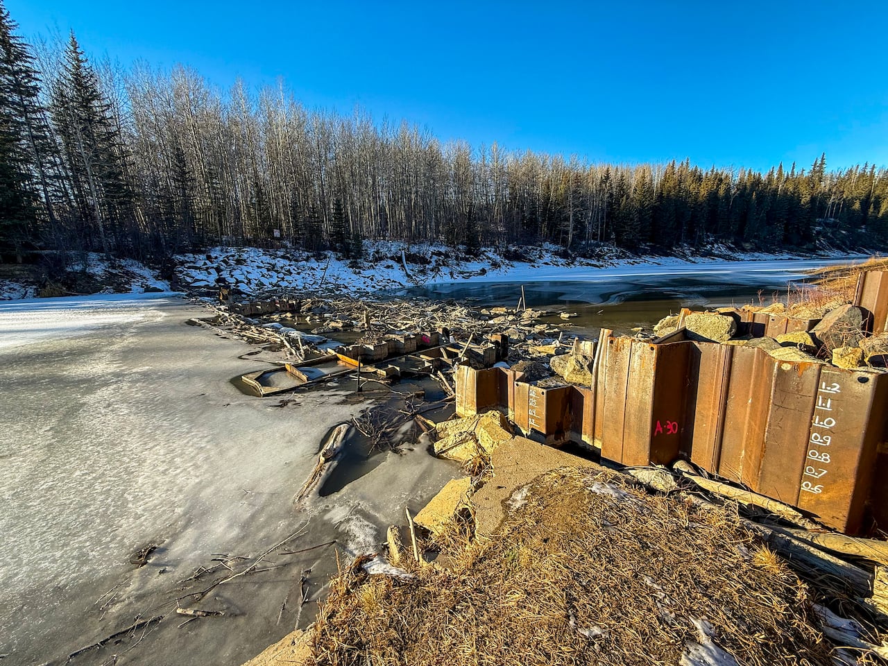 a weir of rocks across a frozen river