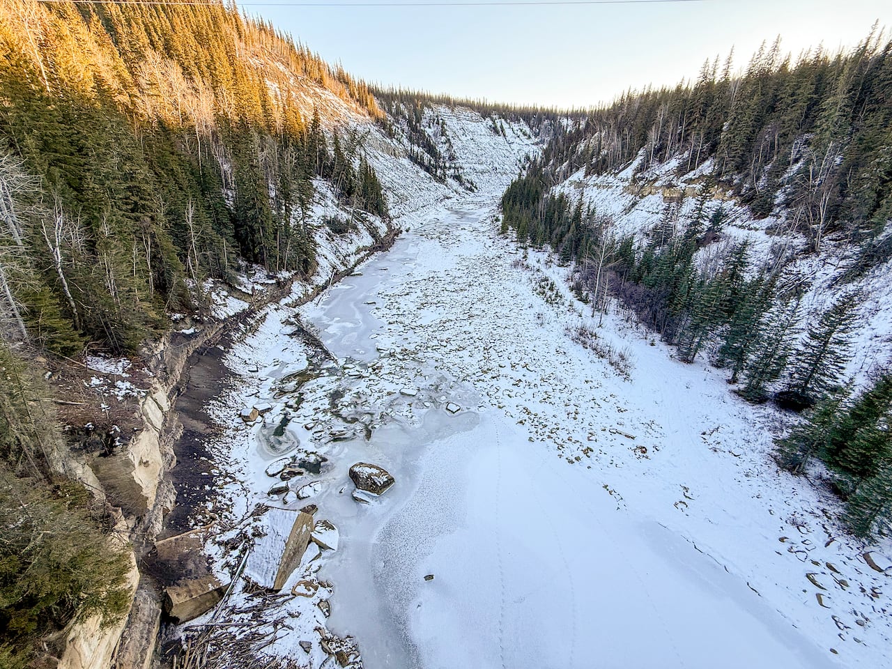a frozen river with low water levels showing a rocky river bed