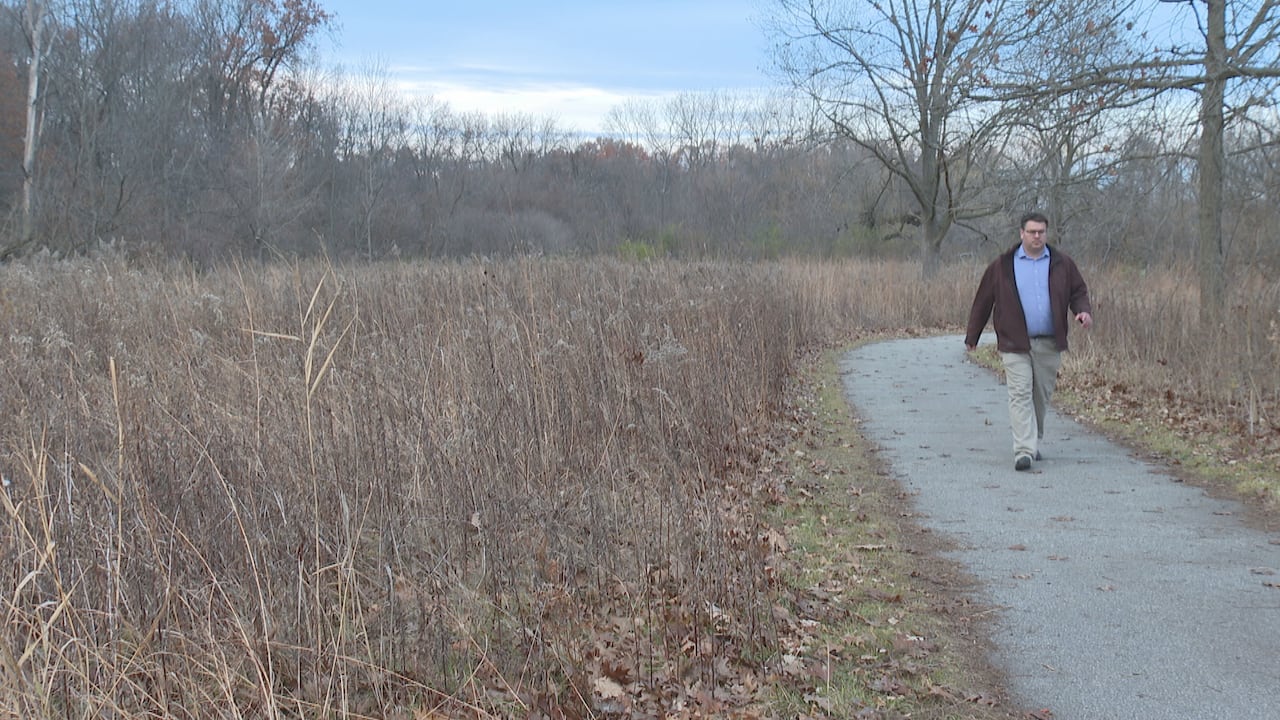 A man walking in a natural area.