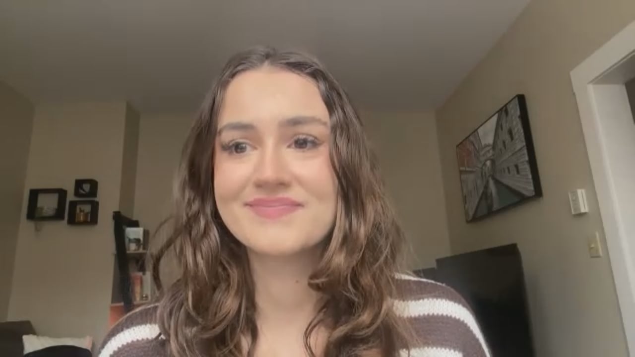 A woman in a brown and white striped shirt.