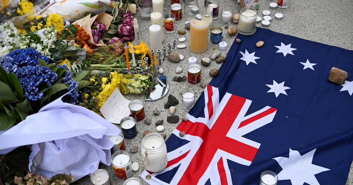 An Australian flag is placed near flowers laid as a tribute to honor the victims of a terror attack that targeted a Hanukkah celebration at Bondi Beach in Sydney, Australia, Dec. 16, 2025.