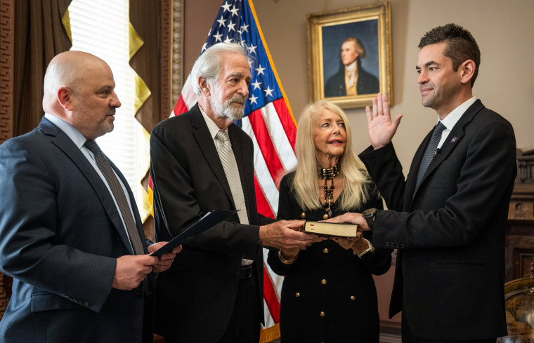 U.S District Judge Timothy Kelly, left, swears in Jared Isaacman, right, as 15th administrator of NASA, as Isaacman's parents, Donald and Sandra Marie join, on December 18, 2025 in Washington D.C.