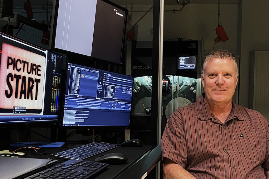 A man sits in a digital studio. 