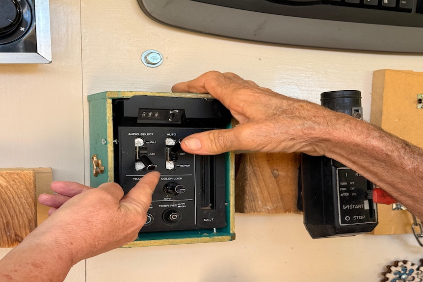 two hands fiddling with a piece of equipment