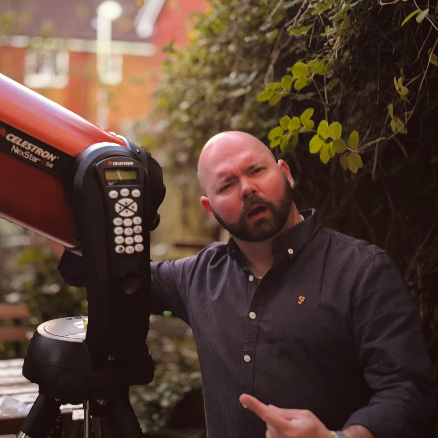 Anthony is pictured standing next to his telescope.