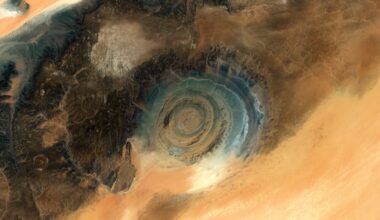 A dark circular eye peers out of a lighter landscape of the Saharan Desert