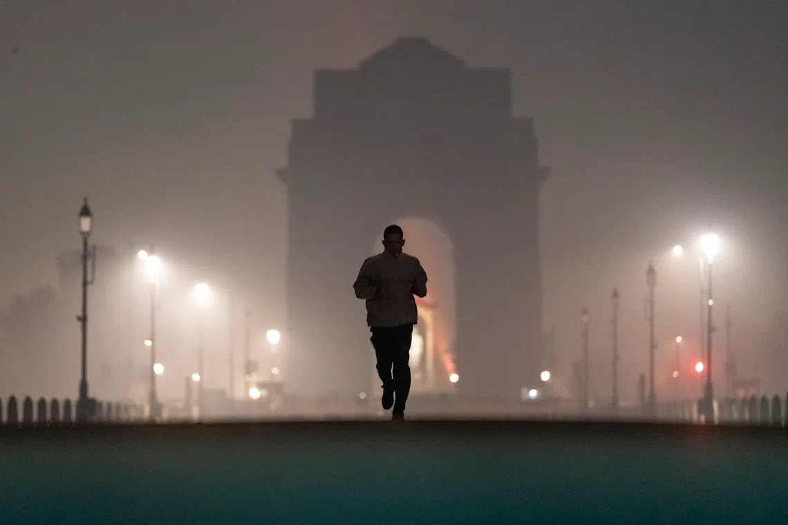 A man jogs near the India Gate which is shrouded in a haze caused in part by air pollution in New Delhi on Nov 24.