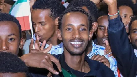 AFP via Getty Images Young men crowd together holding Somaliland flags