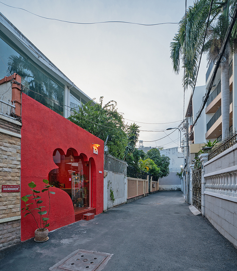 café’s red facade carves welcoming hand-shaped entrance in vietnam