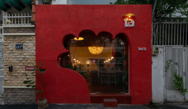 café’s red facade carves hand-shaped entrance in vietnam